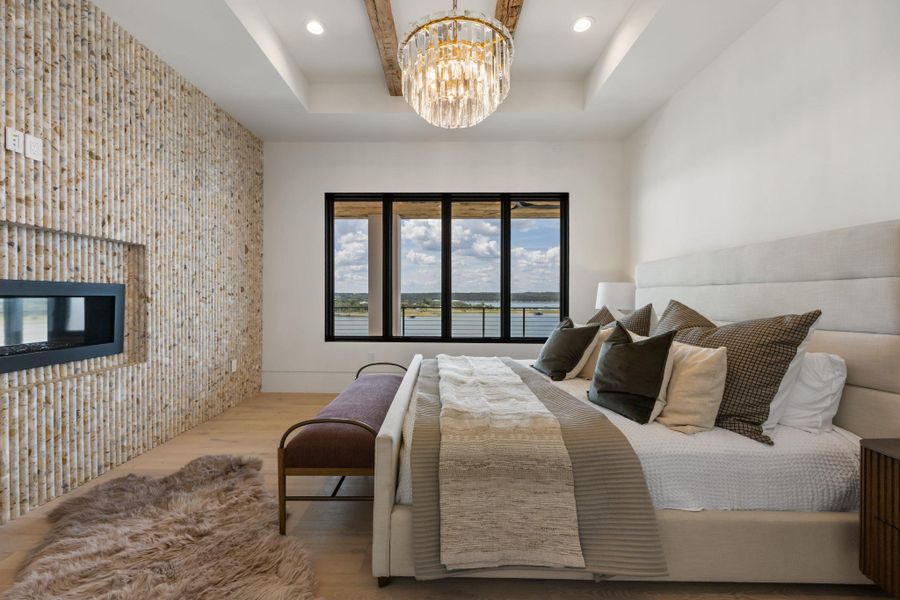 Unwind in this serene bedroom, featuring a captivating fireplace and an inspiring lake view. Unwind in this serene bedroom, featuring a captivating fireplace and an inspiring lake view.