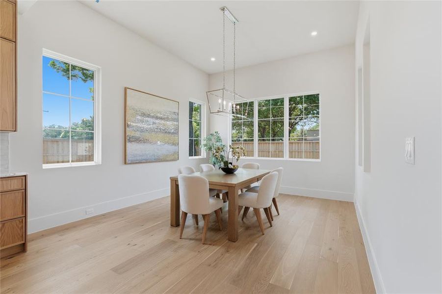Bright dining room with floor-to-ceiling windows, natural light, and tree views Bright dining room with floor-to-ceiling windows, natural light, and tree views