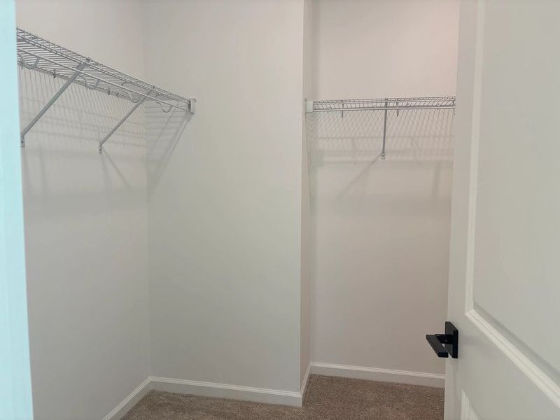 Primary Walk-In featuring the AW Collection® Serene - Open storage with understated design.