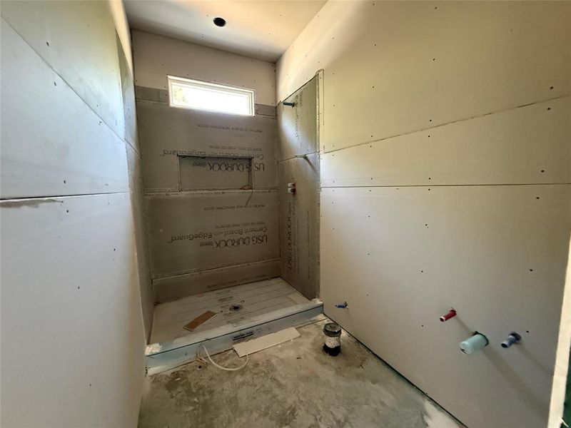 Shower enclosure under construction with cement board backing, integrated niche, and a horizontal transom window