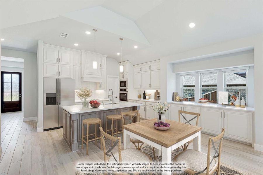 Open kitchen and dining area with white cabinets, gray island, stainless appliances, and wood dining table