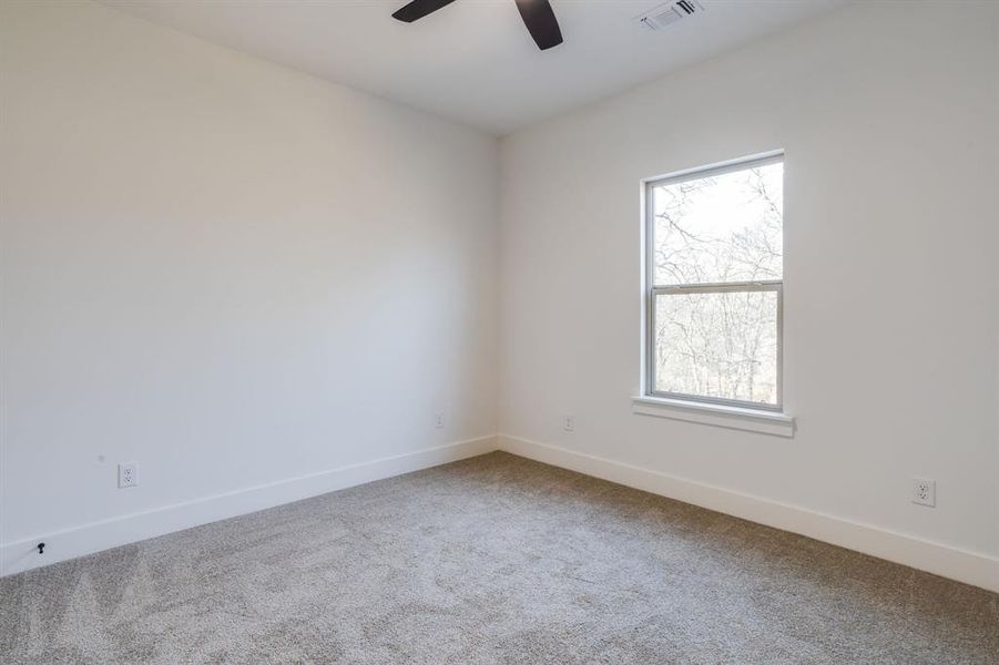 Carpeted empty room featuring baseboards and ceiling fan