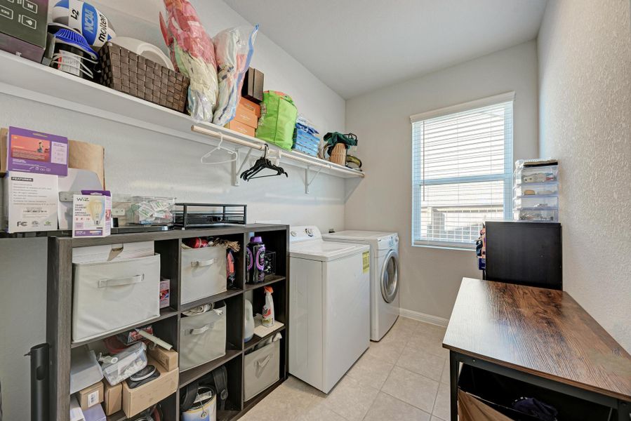 Laundry room with light tile patterned floors and separate washer and dryer