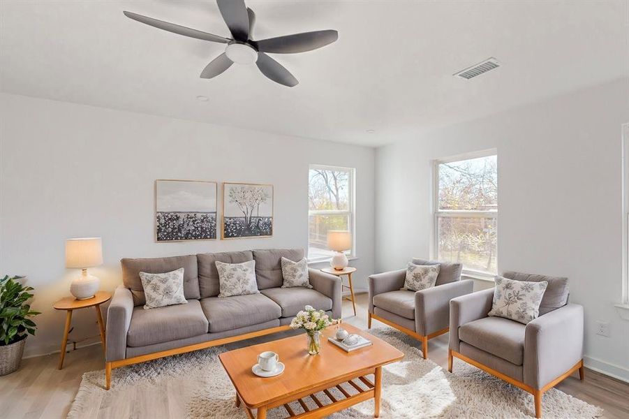 Living room with light hardwood / wood-style floors and ceiling fan