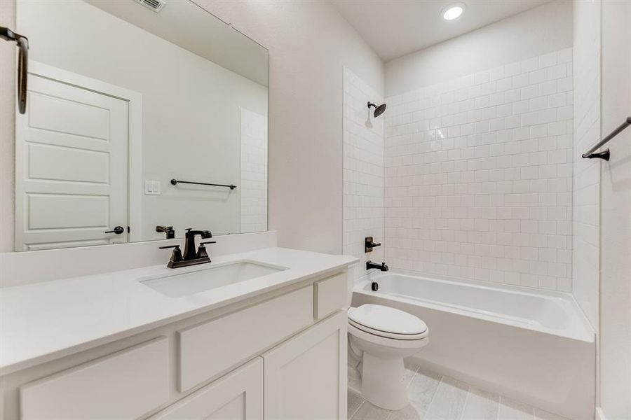 Bathroom with bathtub / shower combination, vanity, recessed lighting, and light tile patterned floors Bathroom with bathtub / shower combination, vanity, recessed lighting, and light tile patterned floors