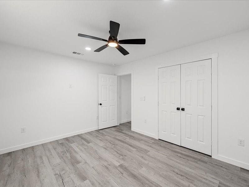Unfurnished bedroom featuring light wood-style floors, a ceiling fan, recessed lighting, and a closet