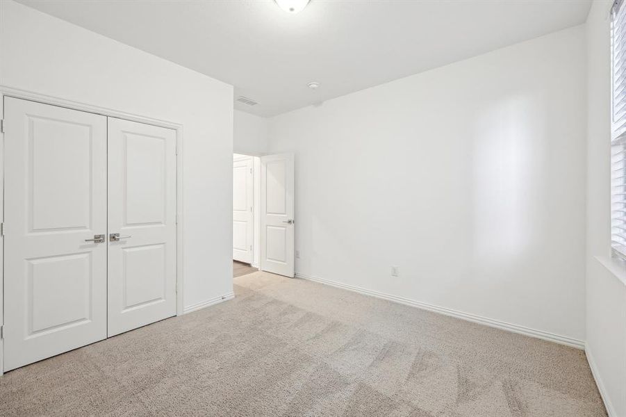 Unfurnished bedroom featuring light colored carpet and a closet