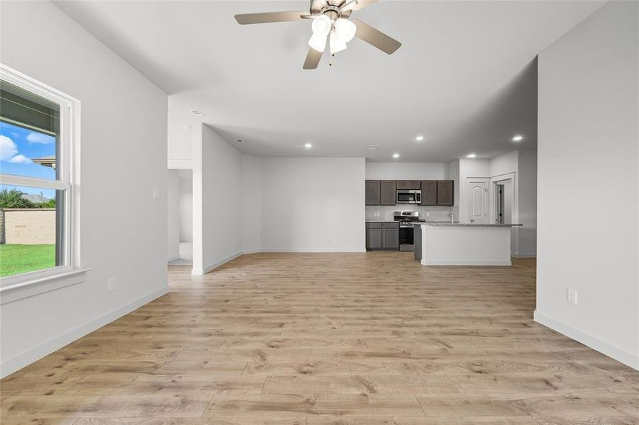 Unfurnished living room featuring ceiling fan, light wood-style floors, and recessed lighting