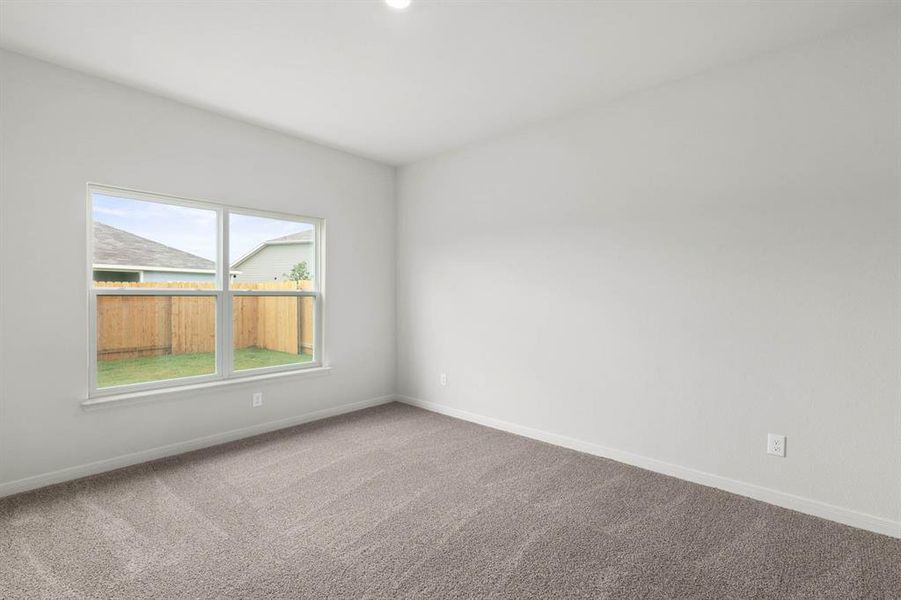 Carpeted spare room with baseboards