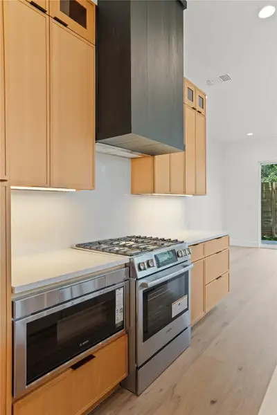 Culinary delights await in this modern kitchen featuring a gas range and built-in microwave.