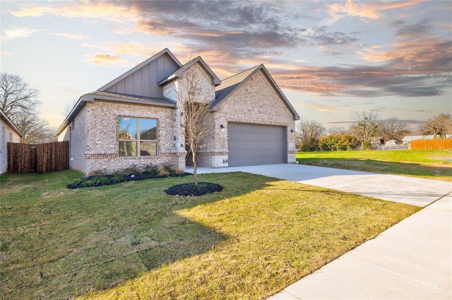 View of front of home featuring a lawn and a garage