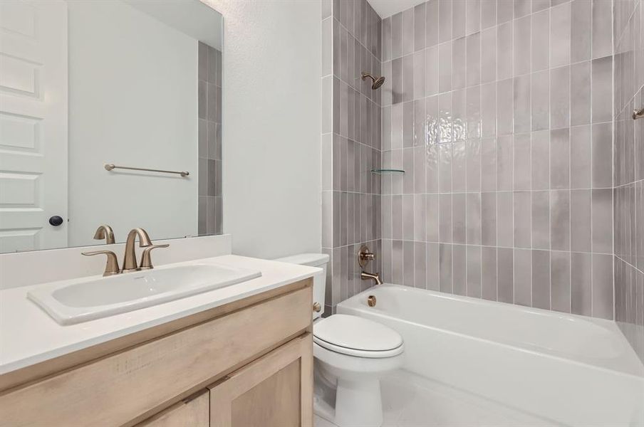 Full bathroom featuring vanity, toilet, and tiled shower / bath combo