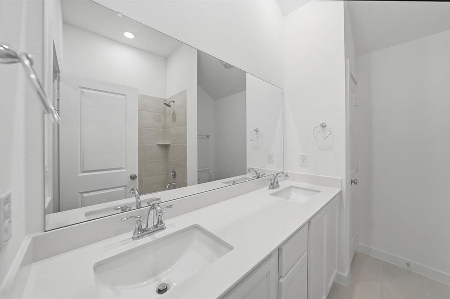 Full bathroom with double vanity and light tile patterned flooring