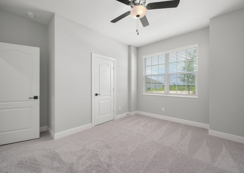 Windows let in plenty of natural light to this secondary bedroom.