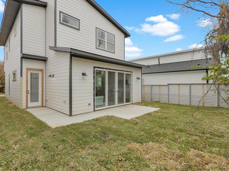 Rear view of property with a lawn and a patio