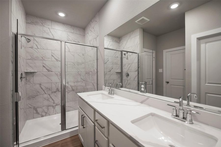 Spa-inspired ensuite with dualvanities, a soaking tub, separateglass-enclosed shower, and a largewalk-in closet. Spa-inspired ensuite with dualvanities, a soaking tub, separateglass-enclosed shower, and a largewalk-in closet.