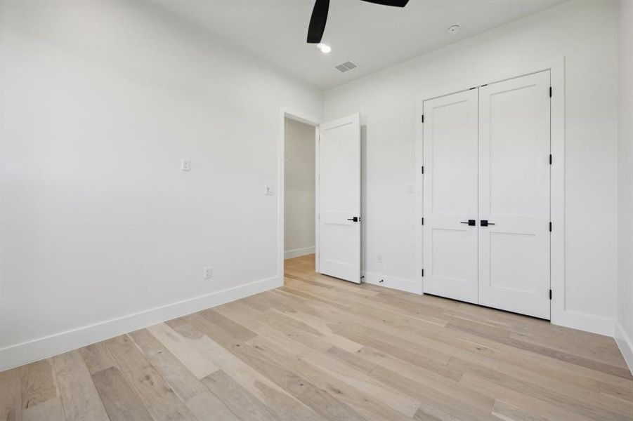 Unfurnished bedroom with light hardwood / wood-style flooring, a closet, and ceiling fan