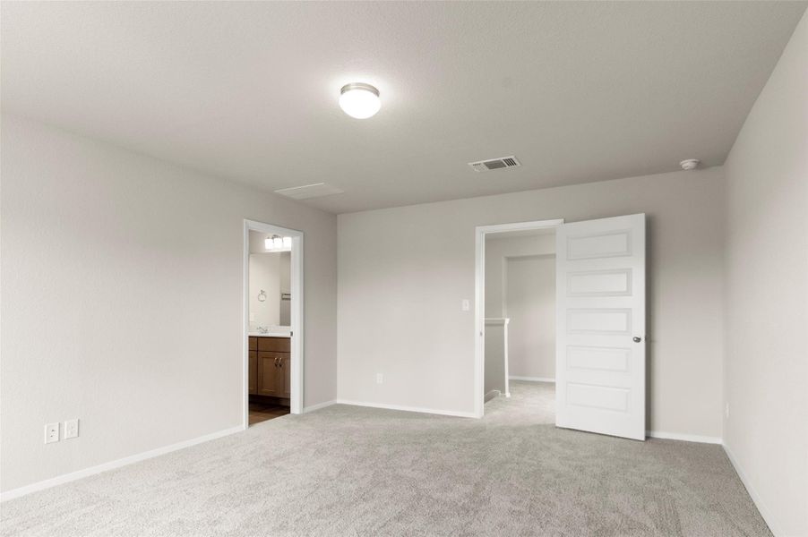 Unfurnished bedroom with carpet floors and ensuite bath