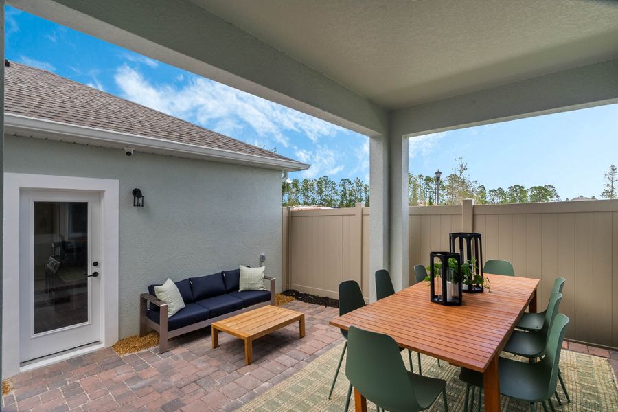 Exterior details and patio area of a home in Harvest at Ovation - Townhomes, Winter Garden (Image 23).