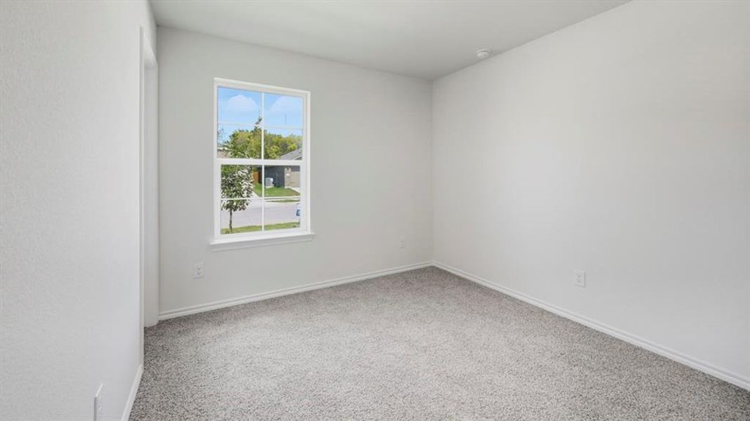 Unfurnished room featuring light carpet and baseboards
