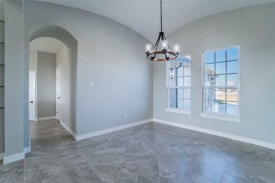 Unfurnished dining area with arched walkways, a chandelier, and vaulted ceiling Unfurnished dining area with arched walkways, a chandelier, and vaulted ceiling