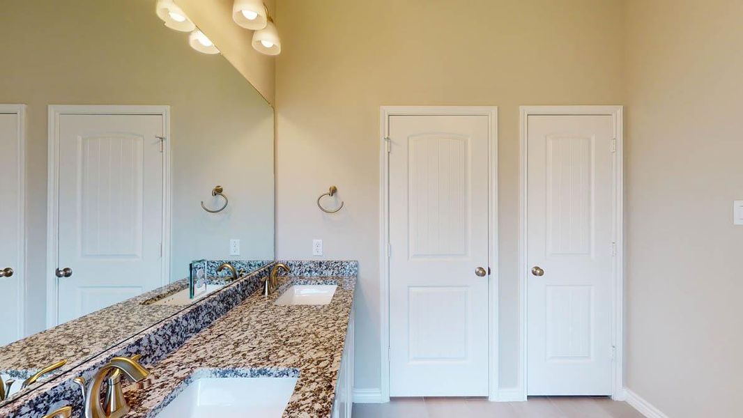 Bathroom featuring double vanity and baseboards