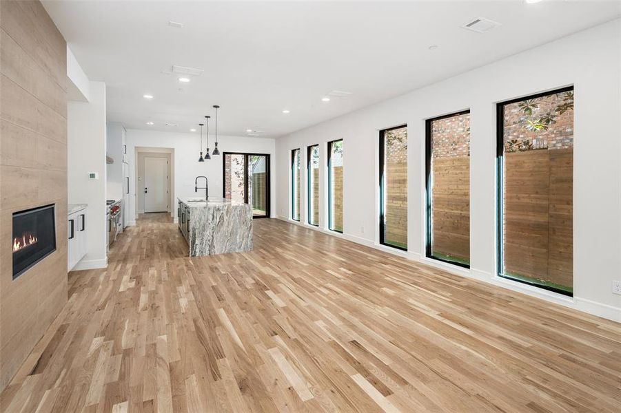 Unfurnished living room with light wood-type flooring, sink, and a tile fireplace