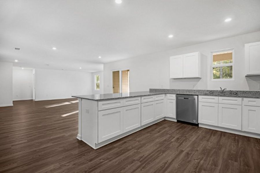 A large kitchen with white cabinets. A large kitchen with white cabinets.
