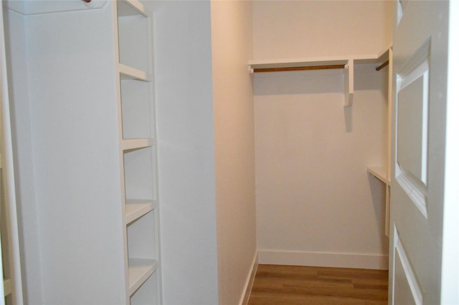 Walk in closet featuring light wood finished floors Walk in closet featuring light wood finished floors