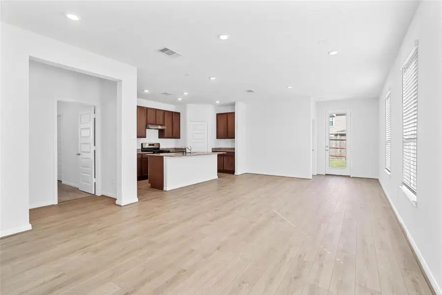 Bring family and friends together in this beautiful Great Room! It features high ceilings, recessed lighting, custom paint, stunning vinyl plank flooring, and large windows that fill the space with natural light all day long.