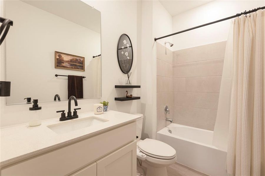 Bathroom vanity featuring a rectangular undermount sink, light-colored countertop, and matte black faucet Bathroom vanity featuring a rectangular undermount sink, light-colored countertop, and matte black faucet
