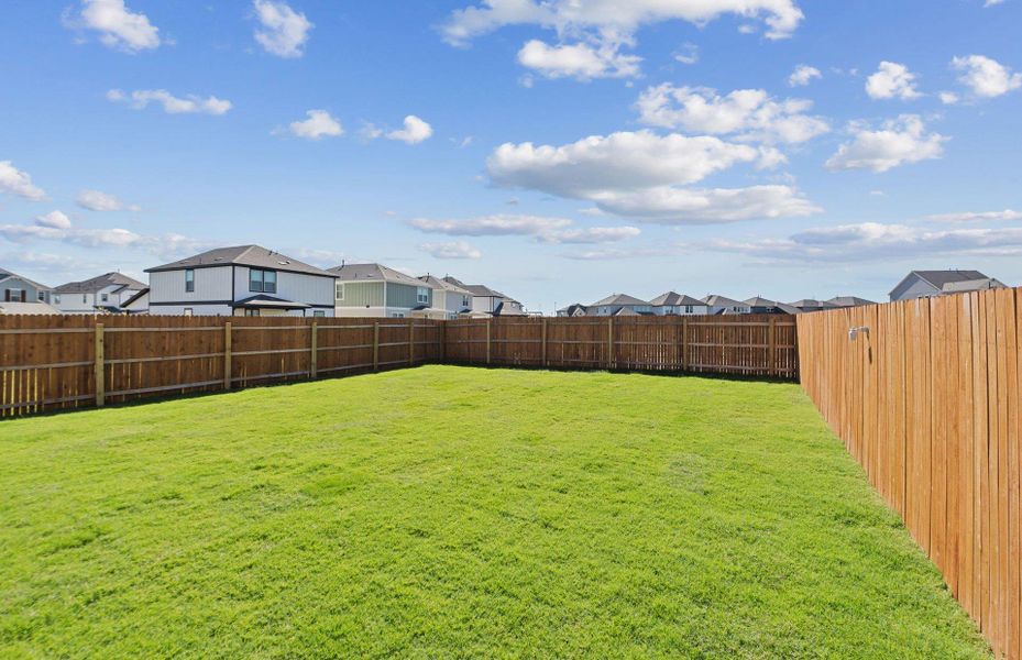 Fenced backyard with a residential view Fenced backyard with a residential view