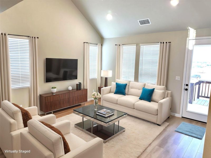 Living area with LVP floors, recessed lighting, high vaulted ceiling, and baseboards Living area with LVP floors, recessed lighting, high vaulted ceiling, and baseboards