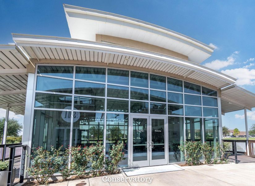 Modern conservatory featuring expansive glass walls and a sleek, curved roof design, surrounded by lush landscaping. Modern conservatory featuring expansive glass walls and a sleek, curved roof design, surrounded by lush landscaping.