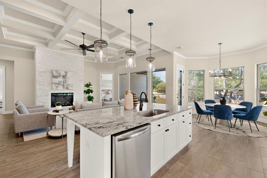 Modern kitchen island with a granite countertop, undermount sink, and stainless steel dishwasher