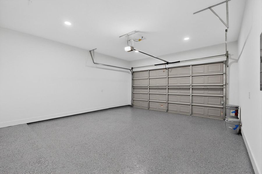 An immaculate garage boasts a fresh epoxy floor and automatic door for effortless access.