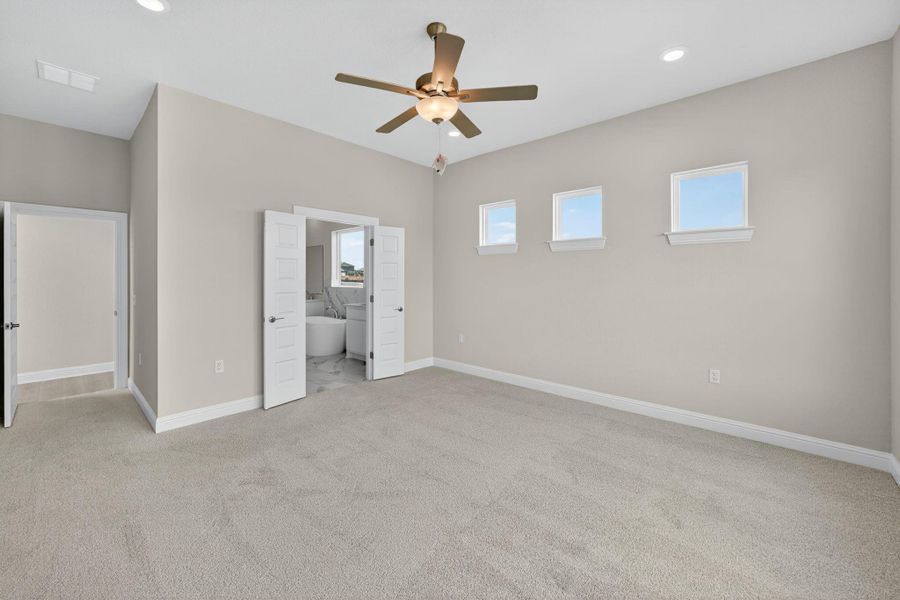 Unfurnished bedroom with light colored carpet, a ceiling fan, ensuite bath, and recessed lighting Unfurnished bedroom with light colored carpet, a ceiling fan, ensuite bath, and recessed lighting
