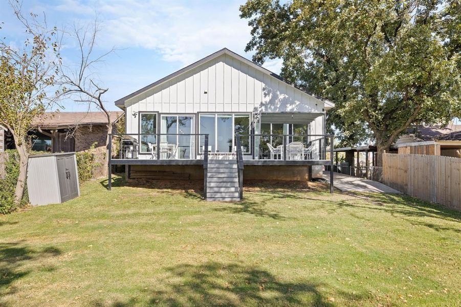 Back of property featuring a wooden deck, board and batten siding, and stairs