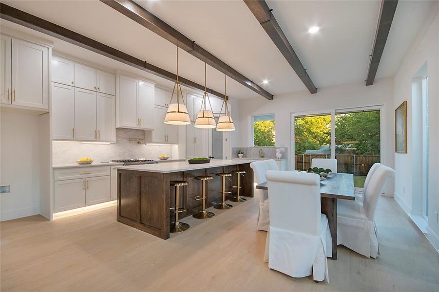 Dining area with beamed ceiling, light wood-type flooring, and recessed lighting