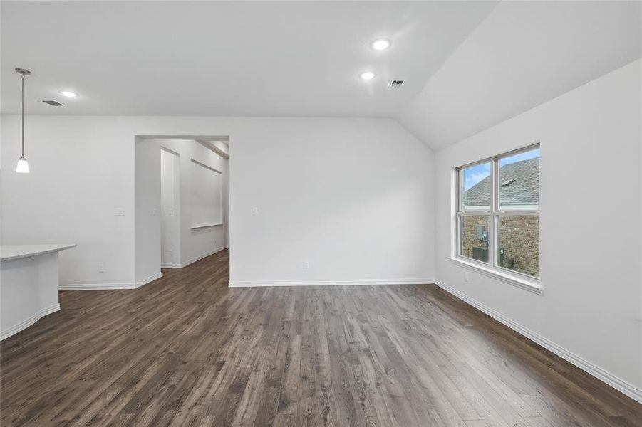 Unfurnished living room with visible vents, dark wood-style flooring, baseboards, recessed lighting, and vaulted ceiling Unfurnished living room with visible vents, dark wood-style flooring, baseboards, recessed lighting, and vaulted ceiling