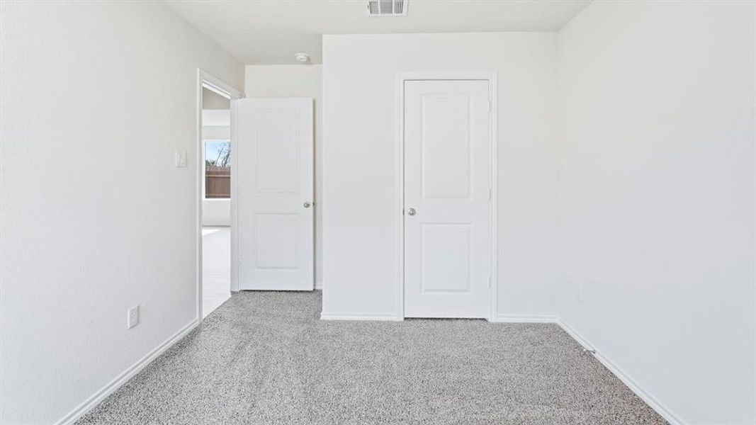 Unfurnished bedroom featuring light colored carpet and baseboards Unfurnished bedroom featuring light colored carpet and baseboards