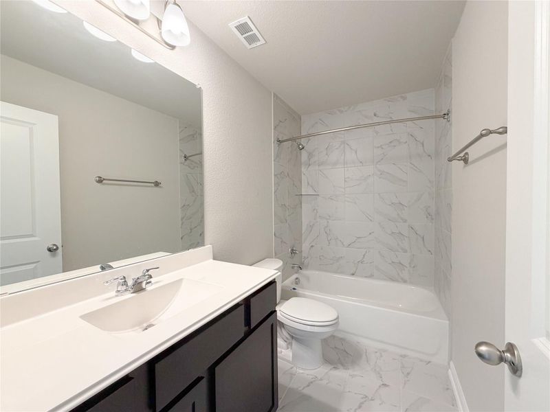 Bathroom featuring a dark wood-finish vanity with a white countertop and integrated sink