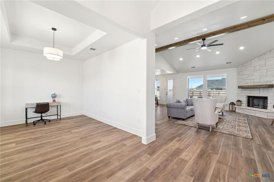 A spacious, airy interior with light wood flooring flows into a comfortable living area anchored by a stone fireplace. A spacious, airy interior with light wood flooring flows into a comfortable living area anchored by a stone fireplace.
