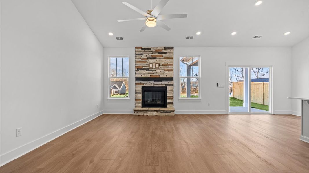 Spacious and stylish family room with two-story ceilings that create a bright and open atmosphere