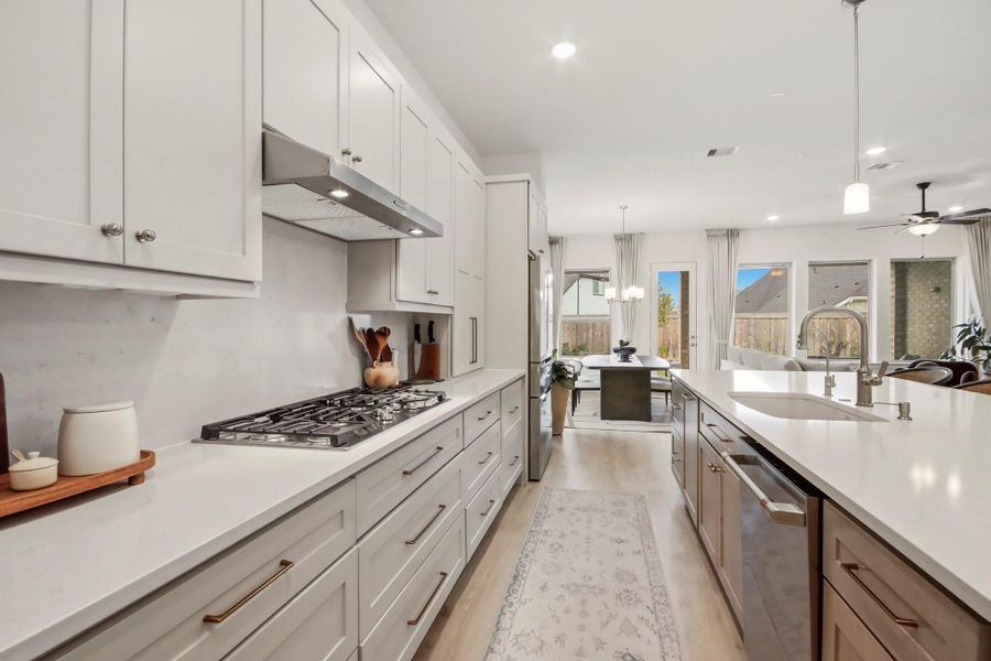 Crisp white cabinetry, a generous center island, and stainless steel appliances define this stylish kitchen, opening effortlessly to the bright dining and living areas.