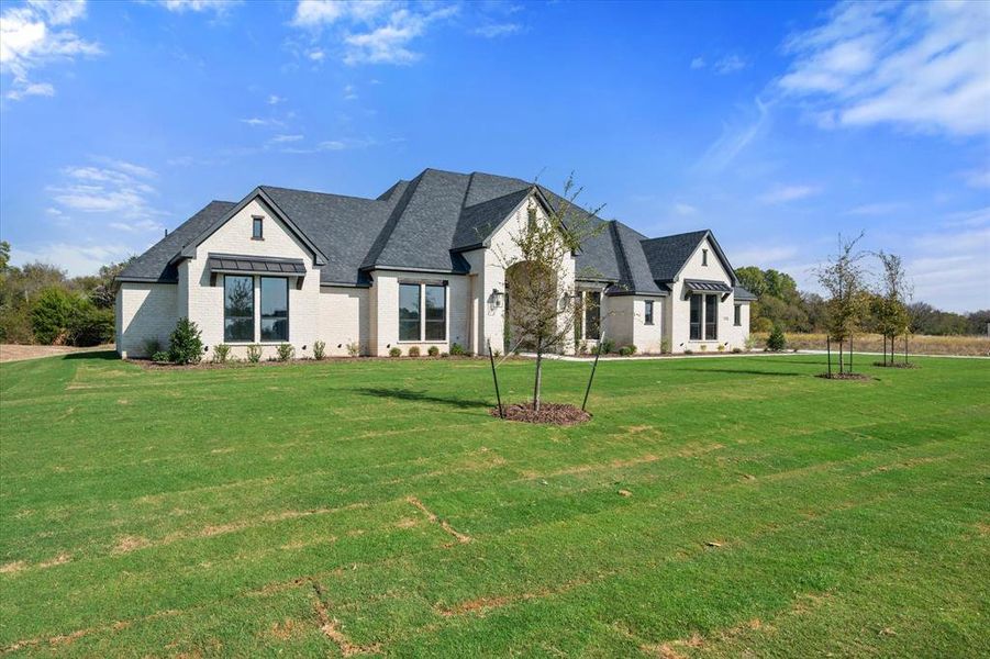 French country home featuring a front yard