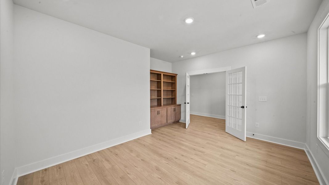Memorable workspace with French doors, built-in shelves, and exceptional light and flow