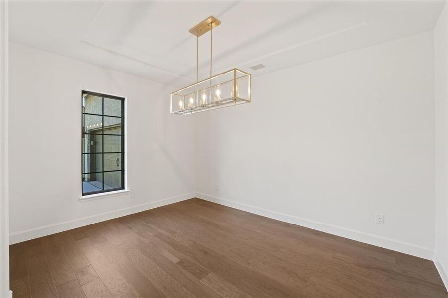 Spare room with dark wood-style flooring and baseboards