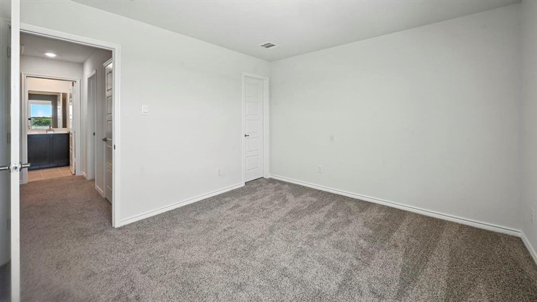 Carpeted spare room featuring baseboards