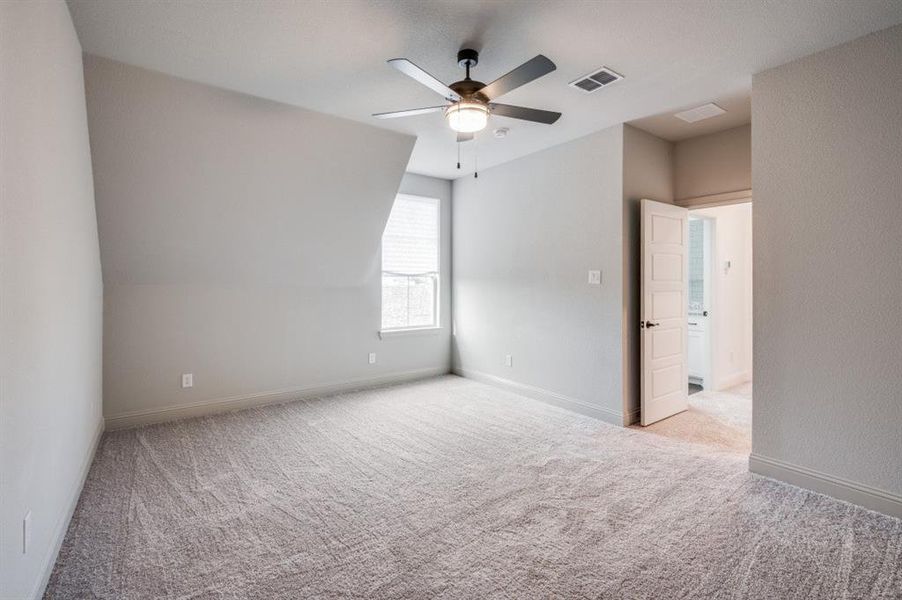 Spare room featuring ceiling fan and light carpet